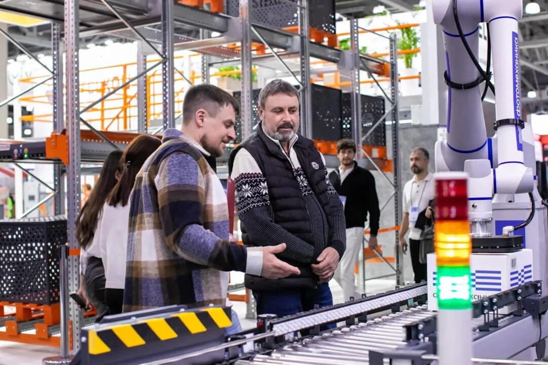 Industrial robot arm in automated manufacturing facility with orange safety lighting