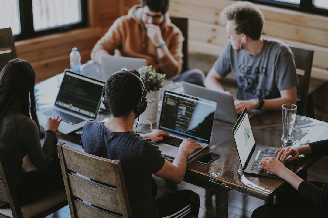 Belgian startup team collaborating around a modern office table with laptops and tablets